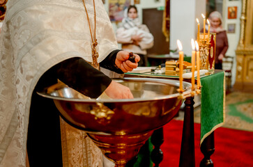 The priest's hand in the bath for the baptism of children