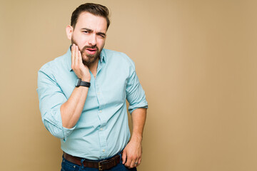 Portrait of a pained man suffering pain because of his wisdom teeth