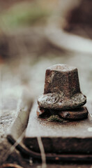 close up of rusty iron screw with washer and thread on a railway. blur background 