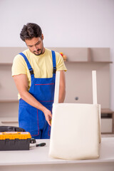 Young male carpenter repairing chair at home