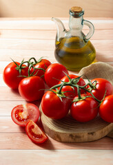 Delicious red ripe tomatoes on a wooden board and a jar of their traditional sauce.