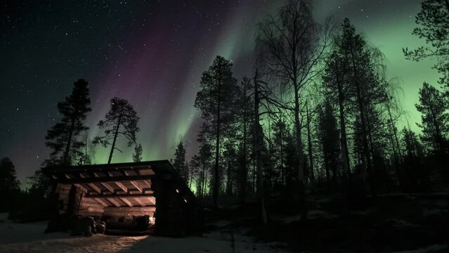 Full-sky auroras behind a lean-to shelter in the wilderness