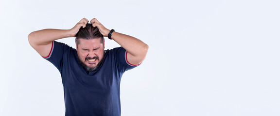 A surprised man scratches his head in disbelief and shock. Reaction after getting fired. Hands on ears. A male of mixed race. Copy space on right.