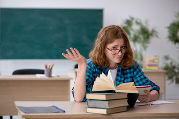 Young female student preparing for exam in the classroom