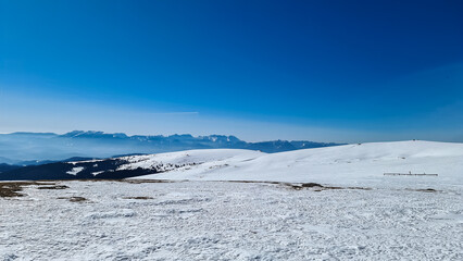 Scenic view of snow covered alpine meadows and Koralpe mountains seen from Ladinger Spitz, Saualpe, Lavanttal Alps, Carinthia, Austria, Europe. Untouched field of snow. Ski touring snowshoeing tourism