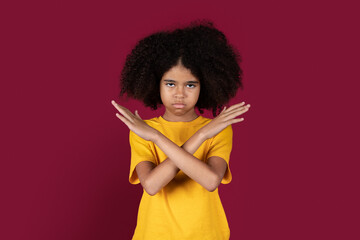 Serious african american girl showing hands crossed, no gesture