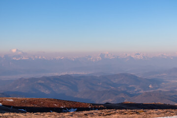 Panoramic view of the Karawanks (Karawanken) mountain range early morning after sunrise seen from Saualpe, Lavanttal Alps, Carinthia, Austria, Europe. Snowcapped mountain peaks in misty atmosphere