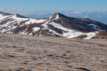 Woman hiking on frozen alpine meadow from Ladinger Spitz to Gertrusk, Saualpe, Lavanttal Alps,...