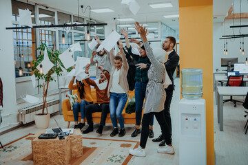 Group of business people throwing paper in air at modern startup office, team success and job done...