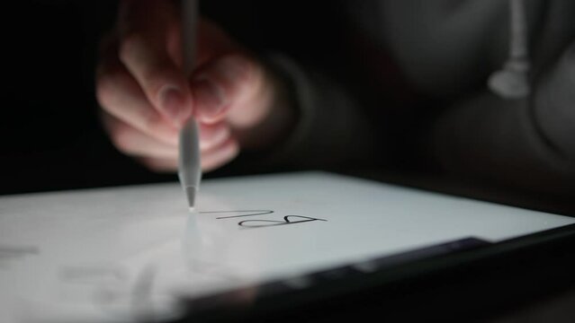 Man writes the word "Buy" on a tablet using a special pencil, digital drawing