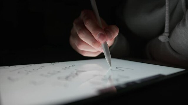 Man writes the word "SELL" on a tablet using a special pencil, digital drawing