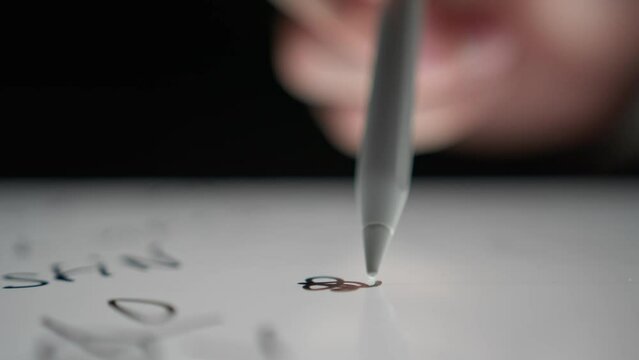 A man draws a squiggle on a tablet using a special pencil, digital drawing, Checking brush thickness, color selection
