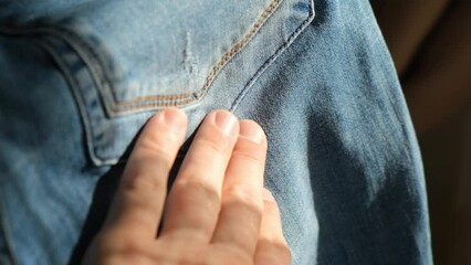 Man touching denim to the touch, close-up