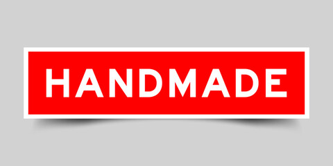 Sticker label with word handmade in red color on gray background