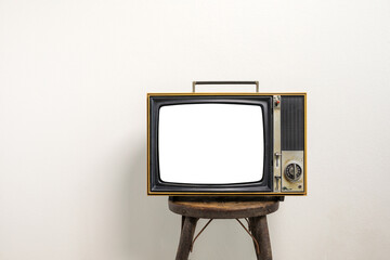 Vintage old television cut out blank screen on bench on white wall background.
