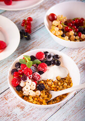 Granola, muesli cereals with yogurt or milk and fresh berries. Healthy breakfast concept.