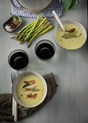 Two ready to eat asparagus cream soup ceramic bowls in a elegant dinner table.