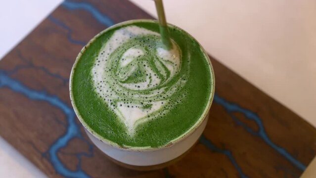 Close-up of a mug of matcha tea with green froth. A cup of hot macha with vegetable milk, an alternative to coffee. Delicious and invigorating matcha green tea drink for energy for the whole day.