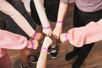 hands of girls with same bracelets, team building, cooperation, support and teamwork. Unity and togetherness concept.