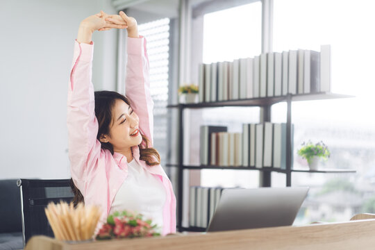 Portrait Of Young Adult Southeast Business Asian Woman Stretching Hand For Relax Break Time At Home Office