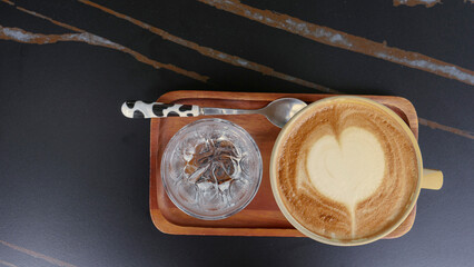 Heart shape of coffee art cup on the dark table