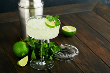 Margarita cocktail with lime, tequila, mint and ice on dark table with amazing backlight, copy space. Classic Margarita or Daiquiry Cocktail. Bar card or counter concept. Selective or soft focus.