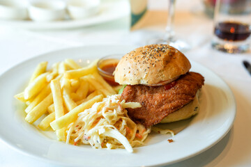 Chicken-Burger mit Coleslaw-Salat und Pommes