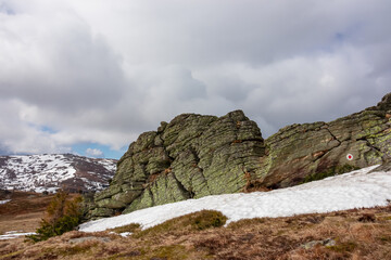Massive rock formation with panoramic view on snowcapped mountain peak Ladinger Spitz, Saualpe,...