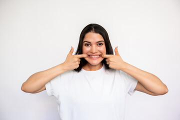 Portrait of crazy young woman grimacing over white background. Caucasian lady wearing white T-shirt...
