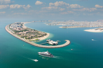 Top view over Dubai palm tree with clear water and, ships and beautiful buildings