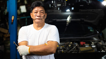 Obraz premium Portrait senior asian male mechanic engineering working on Vehicle in a Car Service. Repair specialist, technical maintenance. Small business owner.