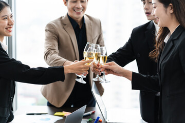 group of Asian business people holding glasses of wine to celebrate new year