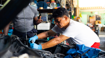 Fototapeta na wymiar senior asian male mechanic engineering working on Vehicle in Car Service. Repair specialist, technical maintenance. Small business owner.