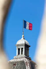 French flag waving at the top of the Palais du Luxembourg (Luxembourg Palace) at the Gardens of...