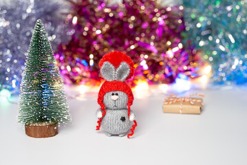 Handmade knitted bunny on a New Year's blurred background