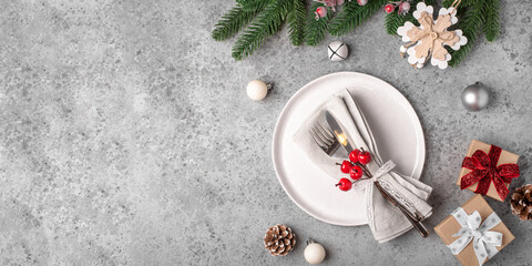 Christmas place setting and decorations on gray table. Copy space for text.