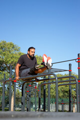 Portrait of active man with prosthetic leg on bars. Young man standing on his both hands on bars raising and working with his legs. Health care and active lifestyle of people with disability concept