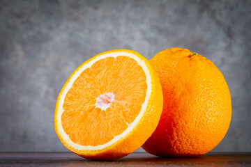 Whole orange and cut half. Orange fruit on concrete texture background. Copyspace.