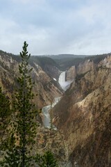Vertical shot of a waterfall flowing through cliffs