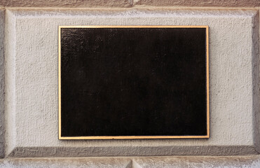 Blank black and white concrete wall. Blank black sign plate on textured wall. Mockup of a plate metal sign	
