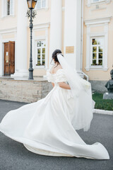 a beautiful bride in a white dress is spinning around herself