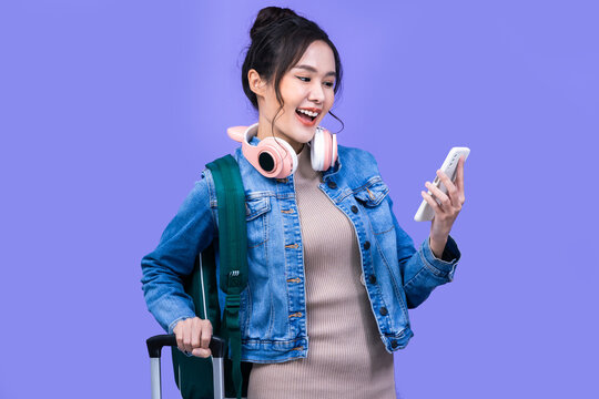 Tourist Asian Woman In Casual Clothes Hat Hold Suitcase Using Mobile Cell Phone Sit Isolated On Colour Background Passenger Travel Abroad Weekends .