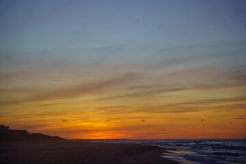 Fototapeta na wymiar Breathtaking view of a sunset sky over a sandy beach and sea in Saint George Island, Florida