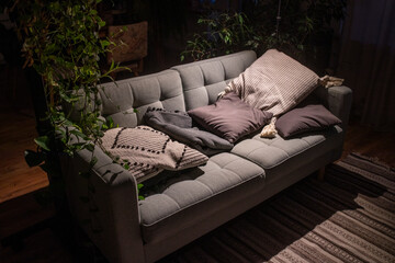 Cozy sofa with pillows in a dark room