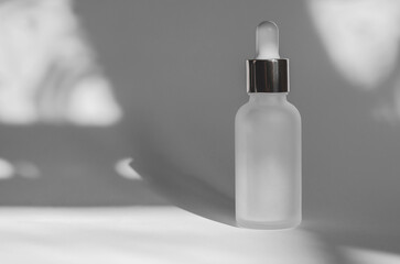 Cosmetic branding mockup. Skin care concept. White cosmetic bottle with essential oil on a white background with shadows.