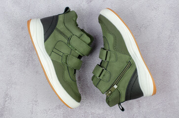 Stylish demi-season men's shoes on a concrete background, top view. Green men's boots