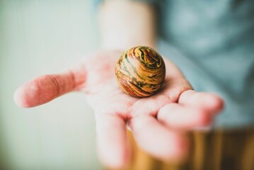 Closeup shot of a person holding a ball that looks like the Jupiter planet