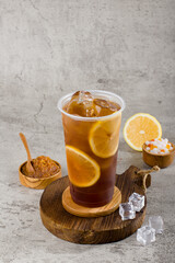 sweet lemonade tea in plastic cup with iced on texture  background, summers refreshment.