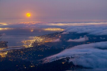 Fototapeta premium Aerial view of a foggy night with Super Moon in San Francisco Bay Area