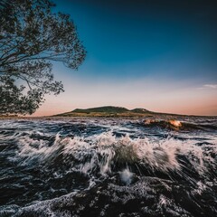 Aerial view of sea waves breaking beach during sunset